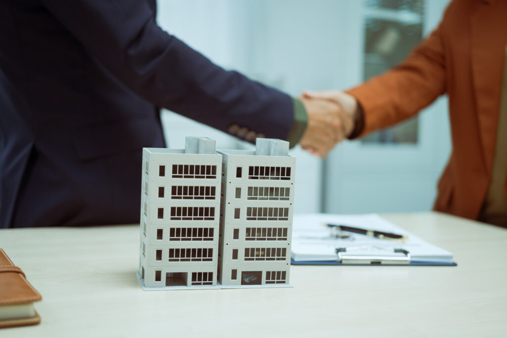 Businessman shaking hands with customer symbolising insurance agreement
